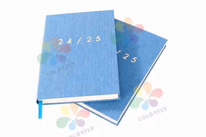 Colorfly A5 sewn binding diary open on desk - magnetic phone attachment and titanium pen slot